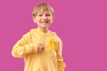 Cute little boy with yellow ribbon on purple background. Childhood cancer awareness concept