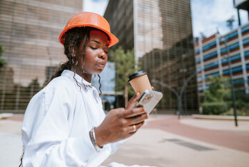 Serious woman with coffee cup browsing smartphone on street