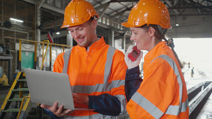 Young caucasian engineer man and woman checking train with laptop in station, team engineer inspect...