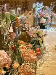  a floral arrangement, likely at a wedding ceremony, featuring orange amaryllis and other blooms. The flowers are arranged in a vase, with greenery and other delicate flowers