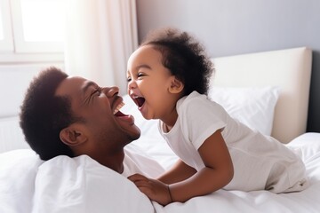 Father and daughter laughing in bed