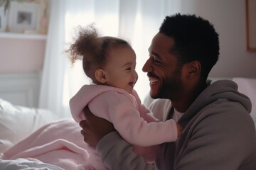 Father and daughter laughing and playing on bed