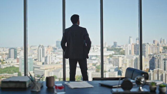 Manager silhouette contemplating city in panoramic office. Company ceo thinking