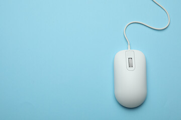 Wired computer mouse on light blue background, top view. Space for text
