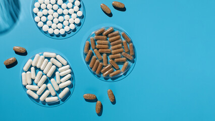 Various vitamins, tablets and dietary supplements on a blue background. Medicine. Copy space