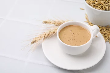  Cup of barley coffee, grains and spikes on white table, closeup. Space for text © New Africa