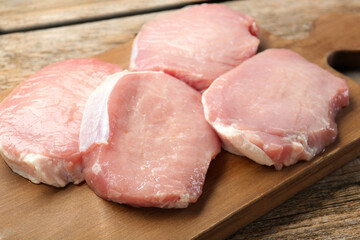 Pieces of raw pork meat on wooden table, closeup