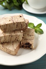 Pieces of tasty chocolate halva and mint on table, closeup