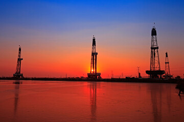 Sunset of oil drilling rig in the sea