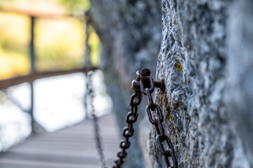 A metal safety chain on a rock in close-up.