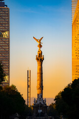 The Angel of Independence statue placed on Promenade of the Reform in Mexico city between tall skyscrapers against morning