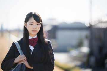 Cute high school girl looking at camera staring outdoors, frontal, serious expression