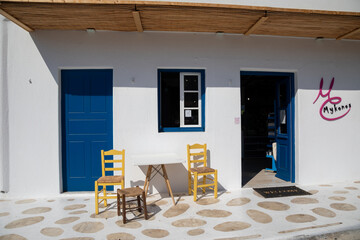Streetview of Mykonos town with white street and blue door, Greece - 711160458