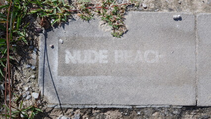 Nude beach writing on the cement floor to show directions