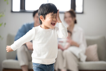 あちゃーと失敗した子どもと見守る家族 いたずらっ子の男児