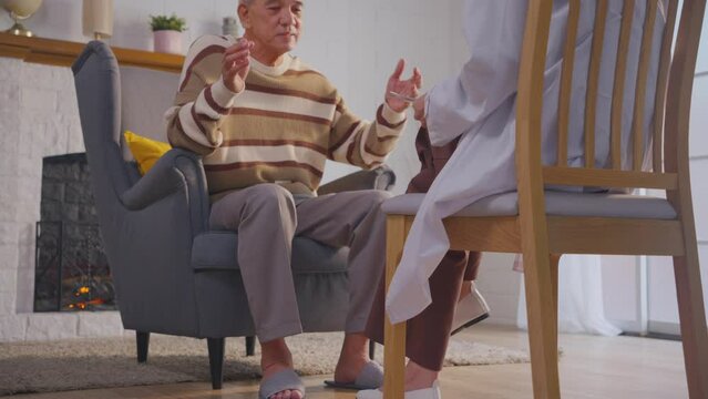 Asian caregiver nurse examine and listen to senior man patient at home. 