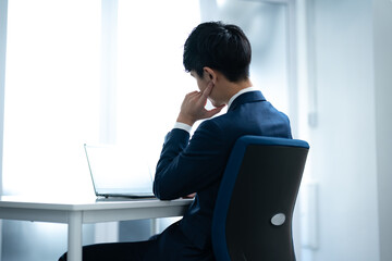 社内でパソコン作業をする若いビジネスマン