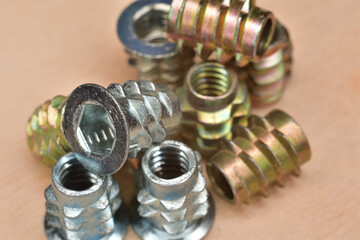 Zink plated coarse thread wood insert. 1/4-20 NC internal thread. Closeup of flanged insert