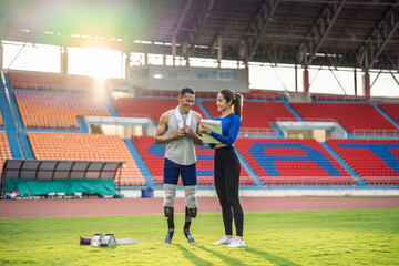 Asian athlete with prosthetic blades and trainer workout in stadium. 