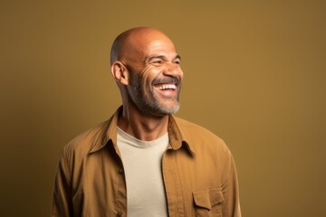 Portrait of a senior man laughing, on a brown background.