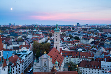 Naklejka premium Aerial Munich Cityscape with Church Tower and Moonrise at Sunset