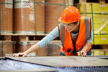 female factory worker using tape measure and measuring steel in the factory