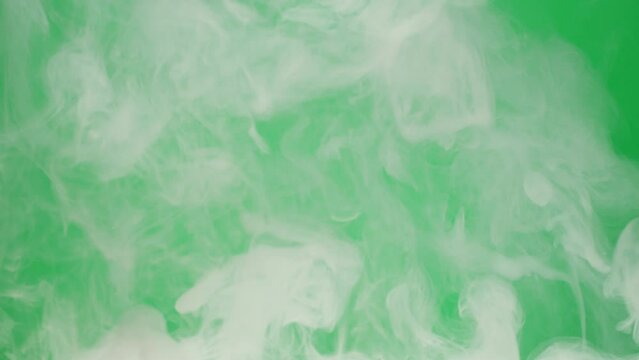 Smoke on green chroma key background. Smoking, steam clouds of vapour close-up. Burning, fog. 