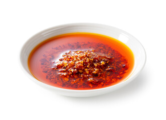 Edible chili oil in a ceramic dish set against a white background.