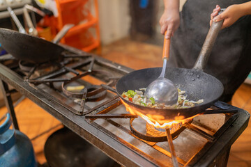 Chef cooking vegetables in a pan in a latin restaurant