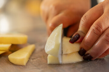 Close-up of the hands of a chef chopping potatoes