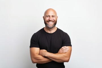 Portrait of a happy bald man in a black t-shirt with crossed arms