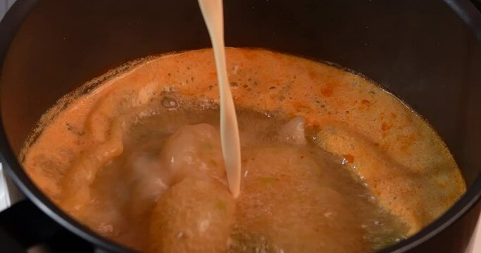 Slow Motion, Adding coconut milk into creamy tom yum soup to thicken the soup, boiling with herbs such as lemongrass, onion, kaffir lime leaves, galangal, parsley, cooking tom yum goong