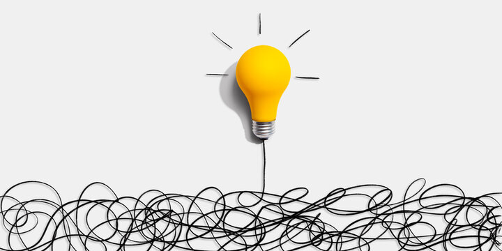 Clarifying complex ideas theme with light bulb - Flat lay