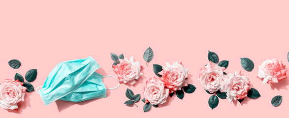 Face masks with pink roses overhead view - flat lay