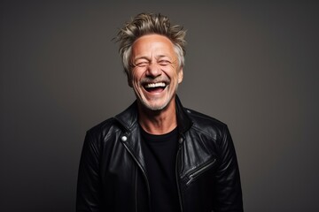 Portrait of a laughing middle aged man in a leather jacket.