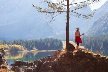 Adult Female Tourist Hiker on Mountain Hike on a Spot near a Mountain Lake in Beautiful Autumn Sunlight