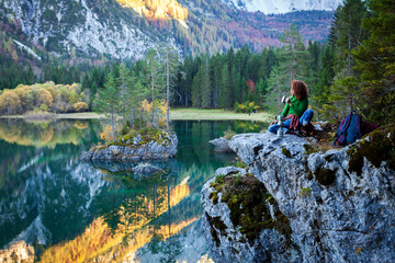 Adventurous Woman Hiker Enjoying a Hot Coffee in Mountains Outdoor Environment Spot near an Alpine Lake