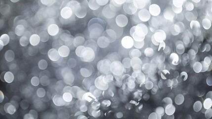 A monochromatic, abstract blurry background in shades of gray, accented with contrasting defocused white lights.