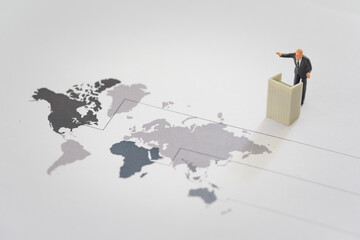 Miniature of businessman stands on podium ladder with world map. Financial and business competition...
