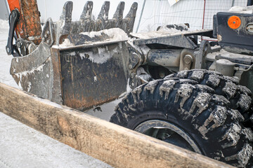 A fragment of an excavator at a construction site on a winter day