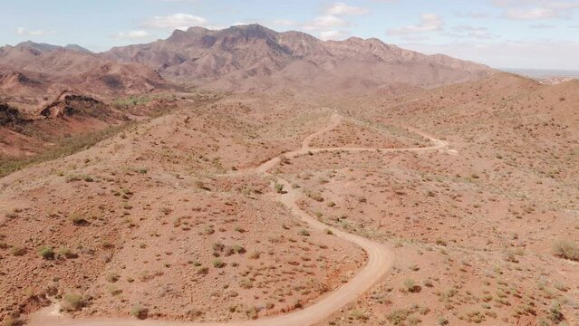 Aerial of Flinders Ranges mountains and winding dirt road, South Australia