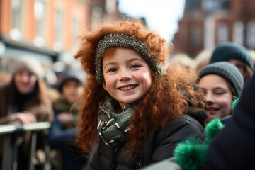 A smiling red haired girl with green clothes at the St. Patrick's Day parade in an Irish town
