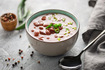 Red bean soup in a ceramic bowl with chili pepper and green onions garnish