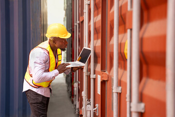 black african man wears hardhat and vest holding laptop computer checking electronic seal on container cargo,young male technician working in shipping yard,concept of container cargo shipping,industry - obrazy, fototapety, plakaty