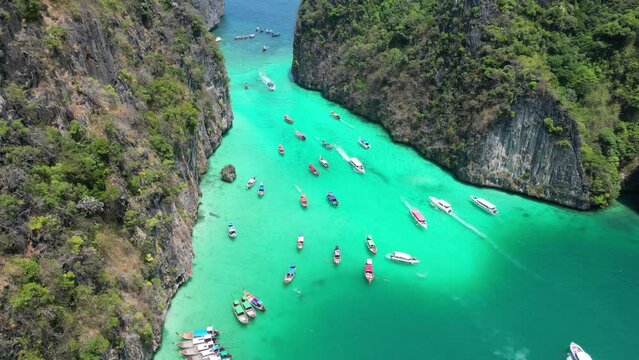 Boats in vibrant Pileh Lagoon of Phi phi island on sunny day, Aerial