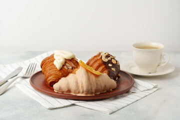 Glazed croissants on clay plate on table