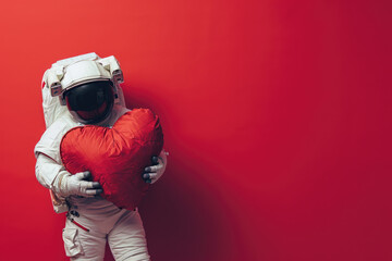astronaut hugging in space and holding a big red heart for valentine's day