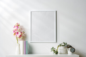 White wooden frame on white wall above the table