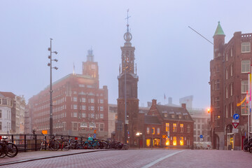 Fototapeta na wymiar Tower Munttoren at Foggy morning in Amsterdam , Holland, Netherlands.
