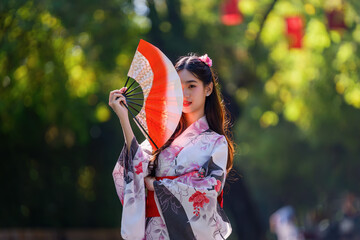 Young women wearing traditional Japanese kimono or yukata is happy and cheerful in the park.